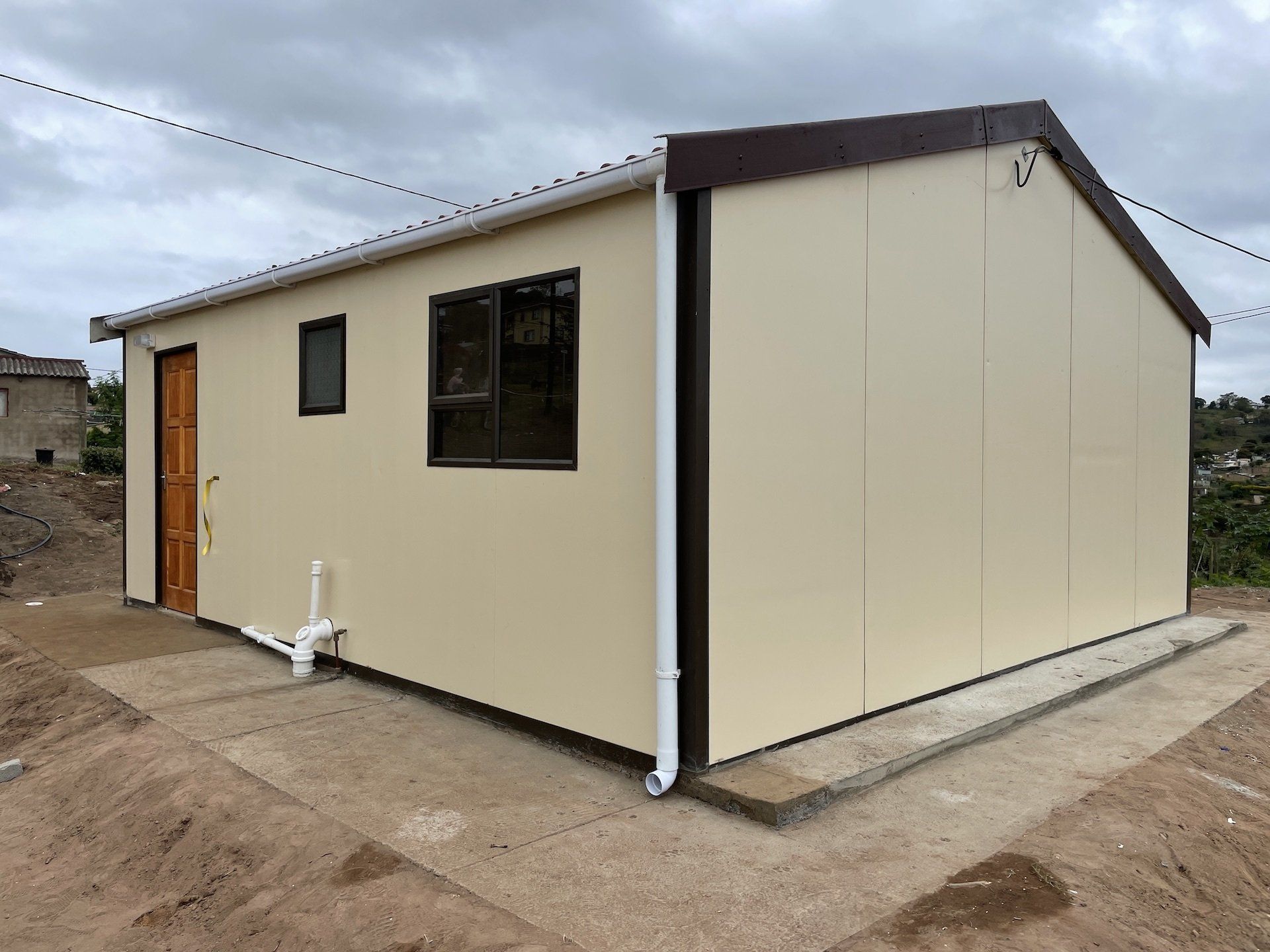 A small house with a brown roof and two windows
