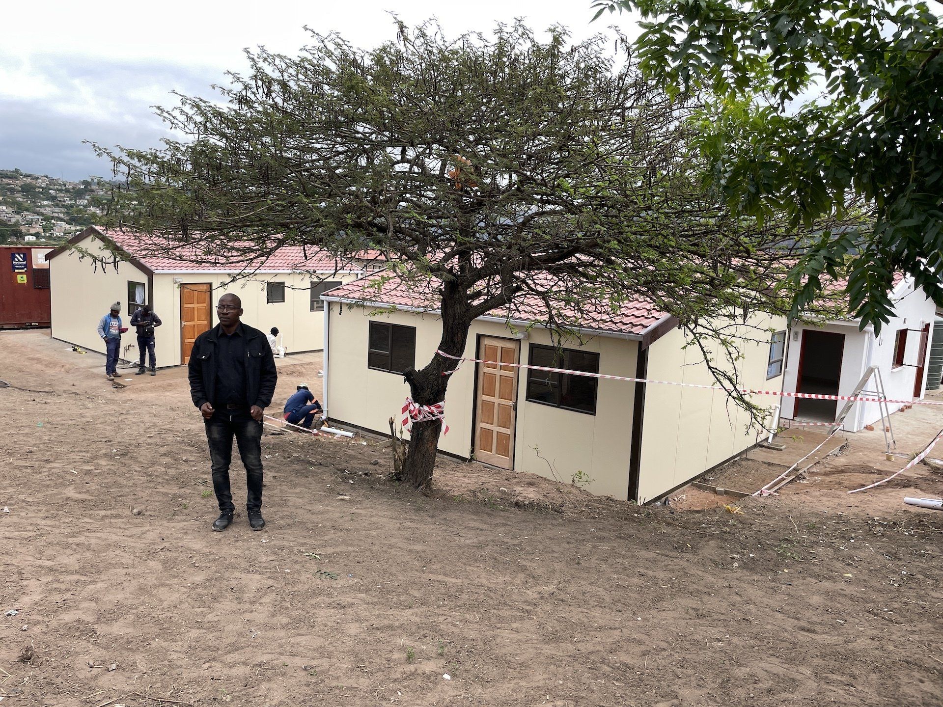 A man is standing in front of a house under construction.