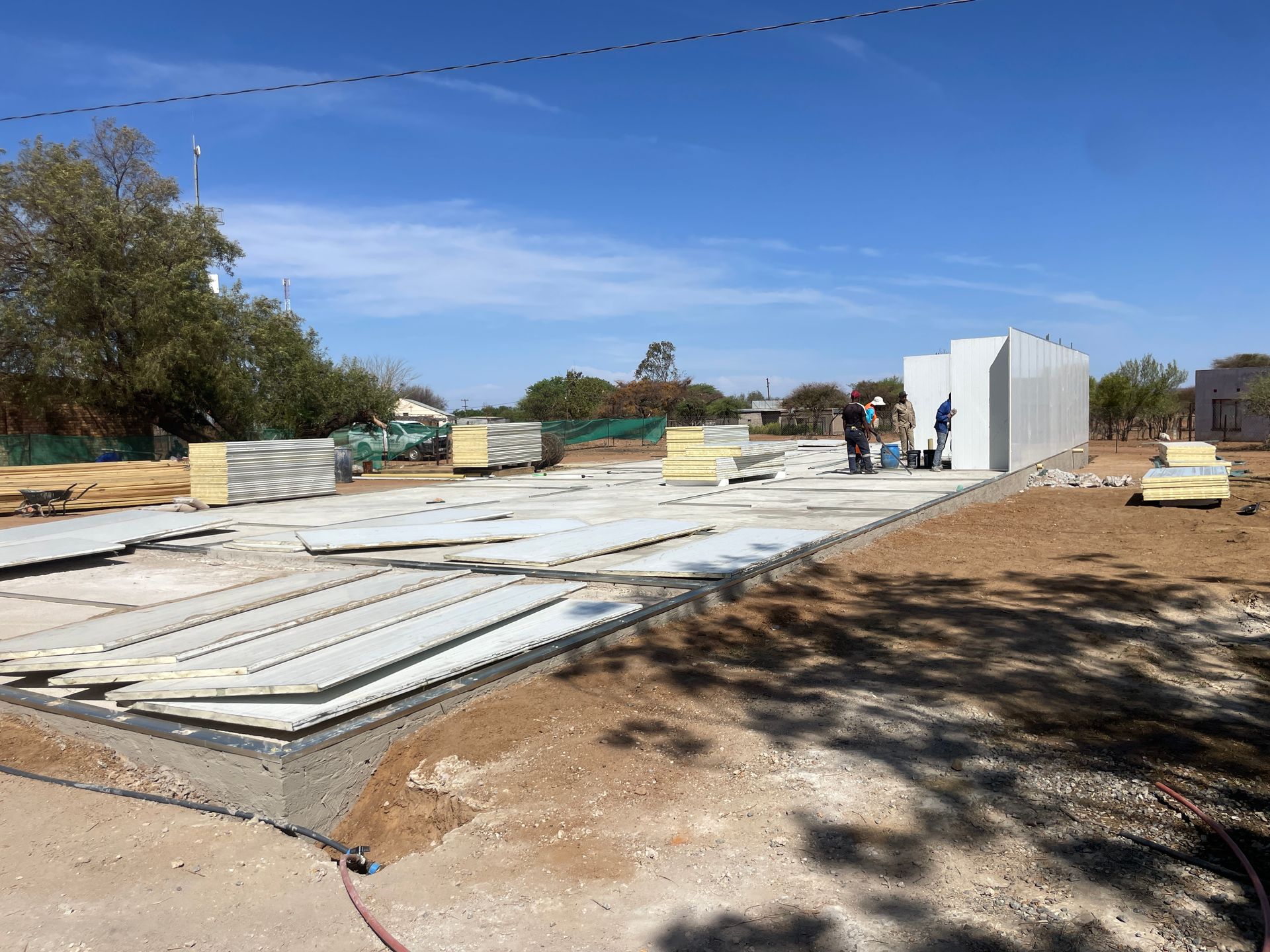 A large concrete structure is being built in a dirt field.