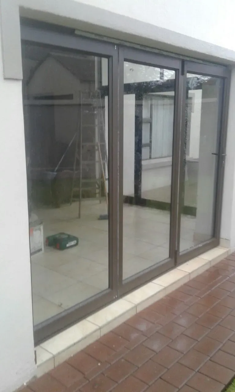 A sliding glass door is sitting on the side of a building.