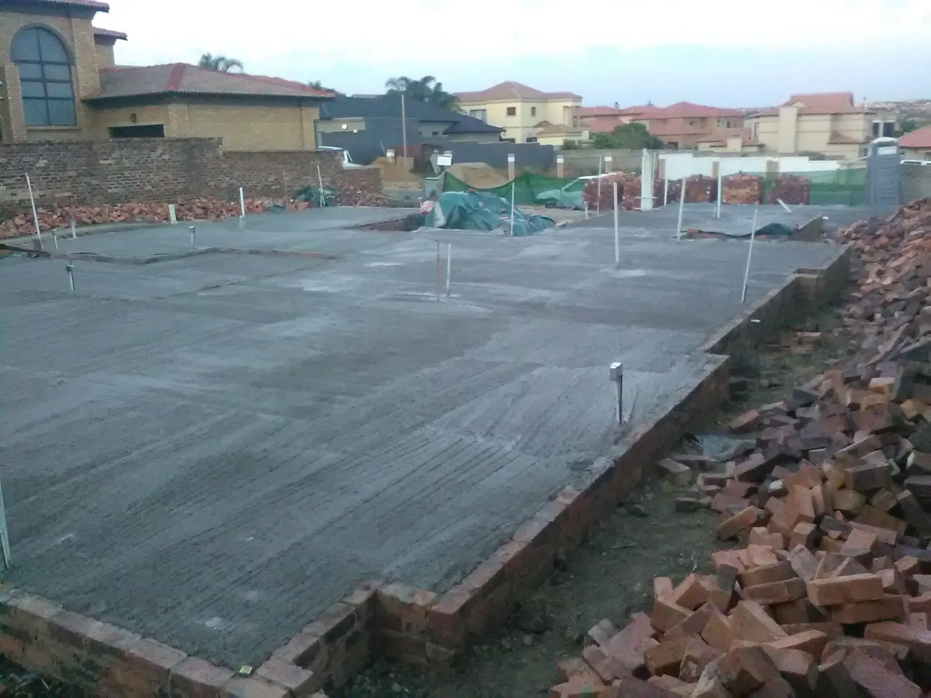 A pile of bricks sits in the middle of a construction site