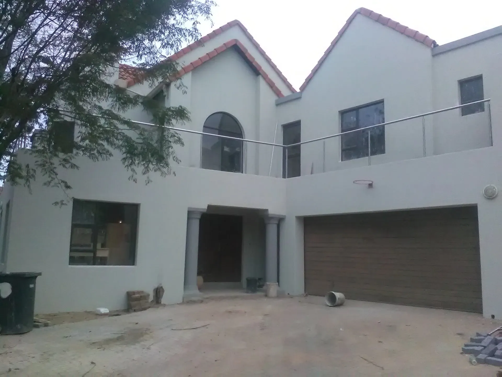 A large white house with two garage doors and a balcony