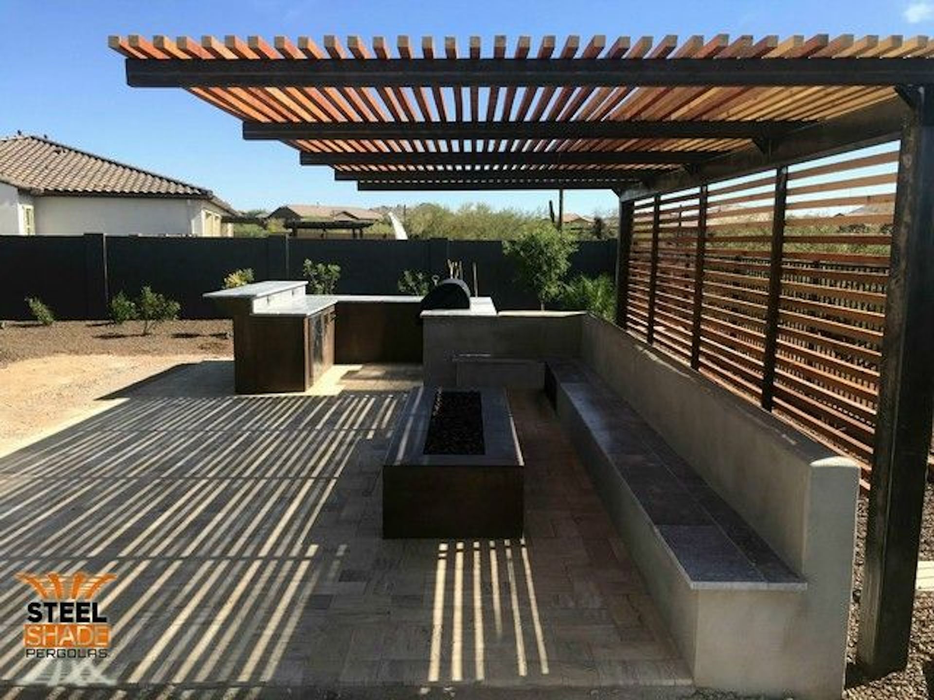 A patio area with a fire pit under a pergola