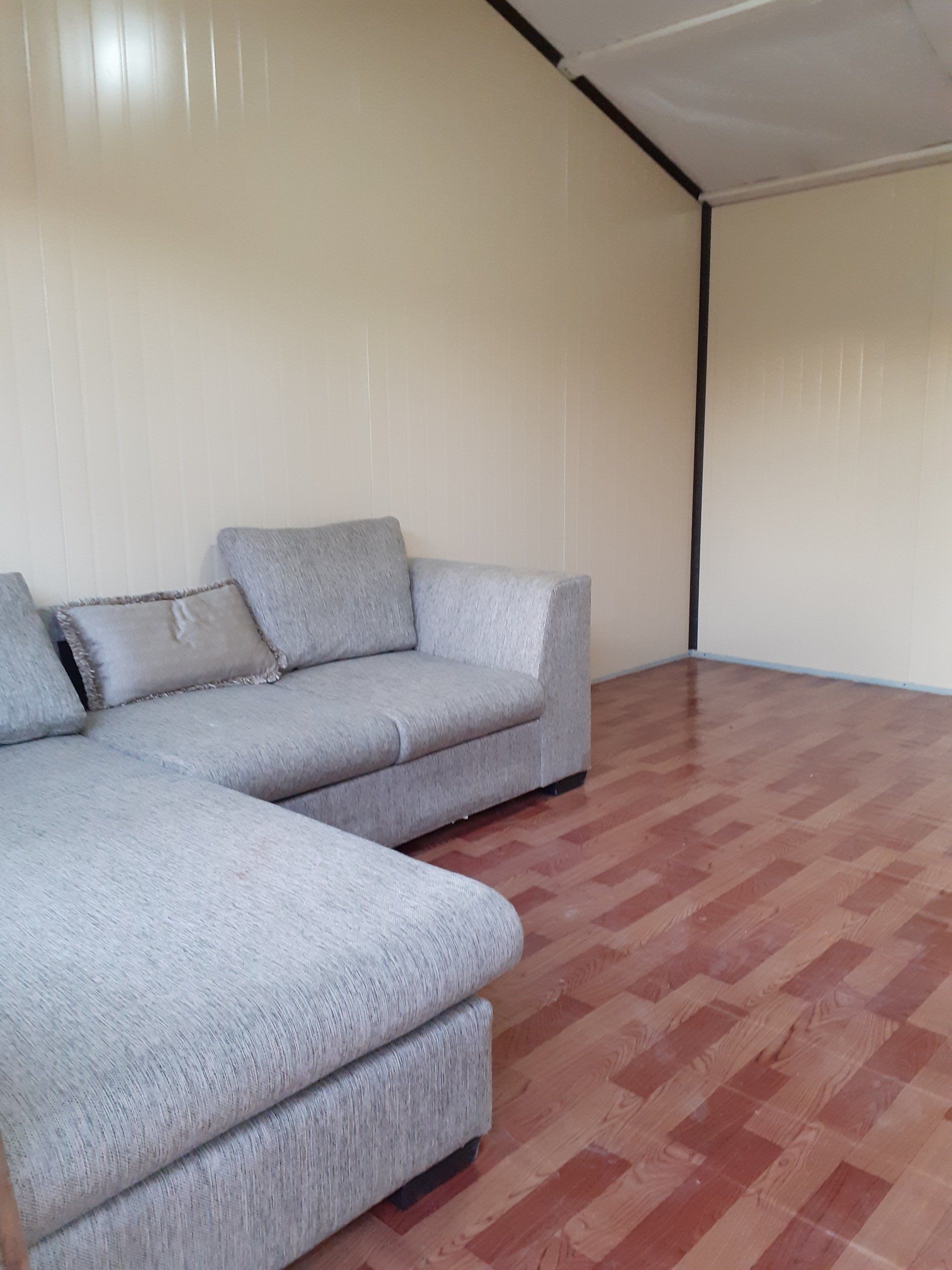 A living room with a couch and a wooden floor