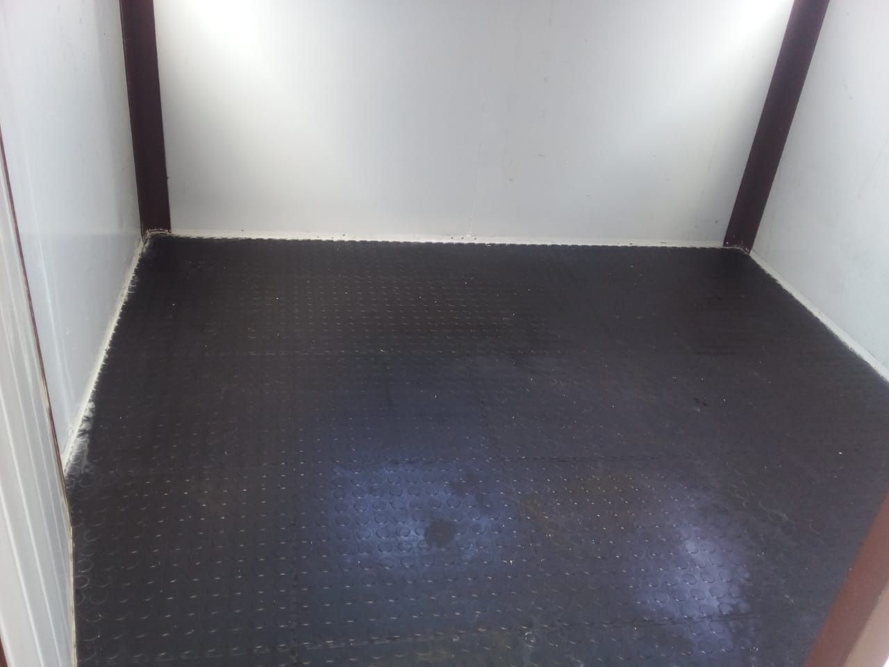 An empty room with a black floor and white walls