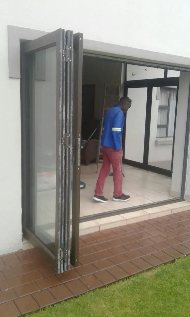 A man is standing in front of a sliding glass door.