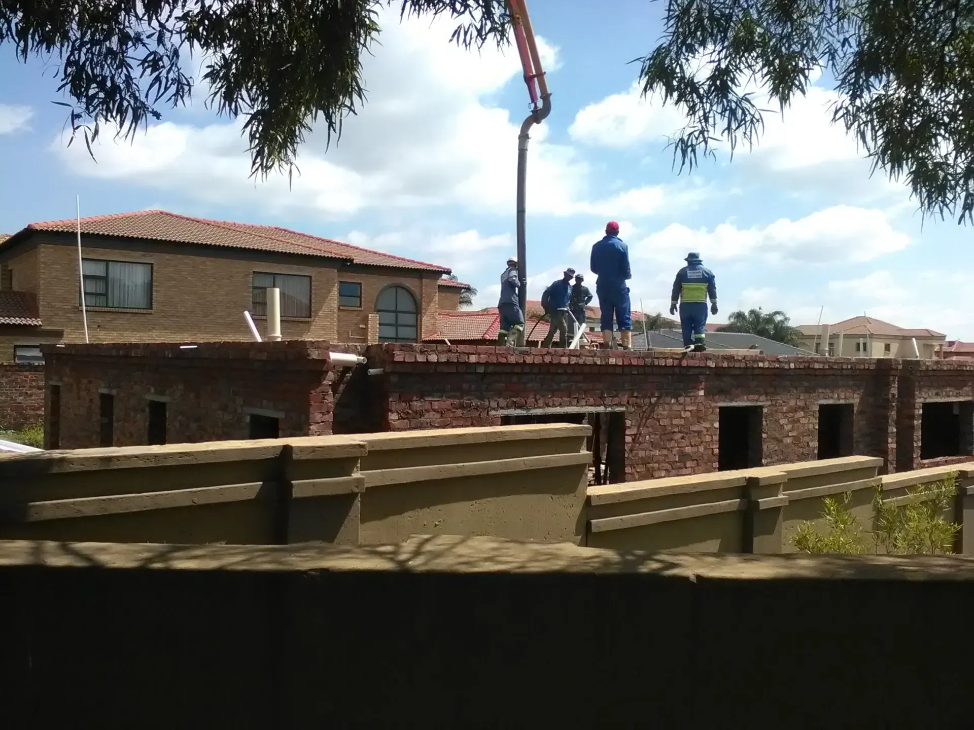 A group of construction workers standing on top of a brick building