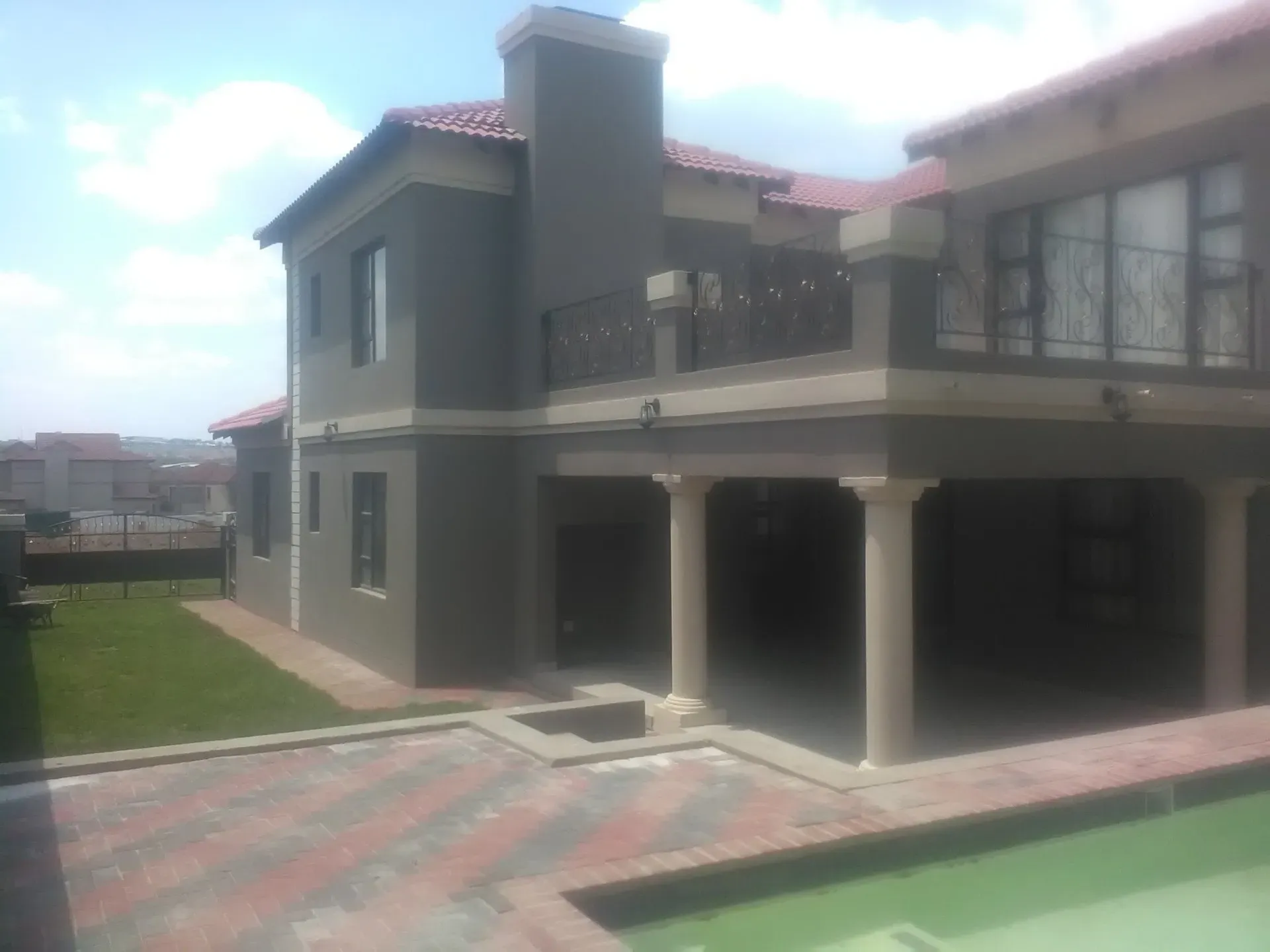 A large house with a swimming pool in front of it