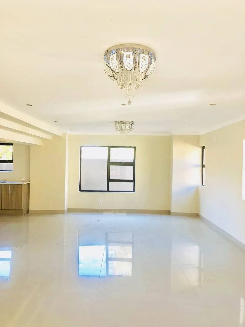 A large empty room with a chandelier hanging from the ceiling.