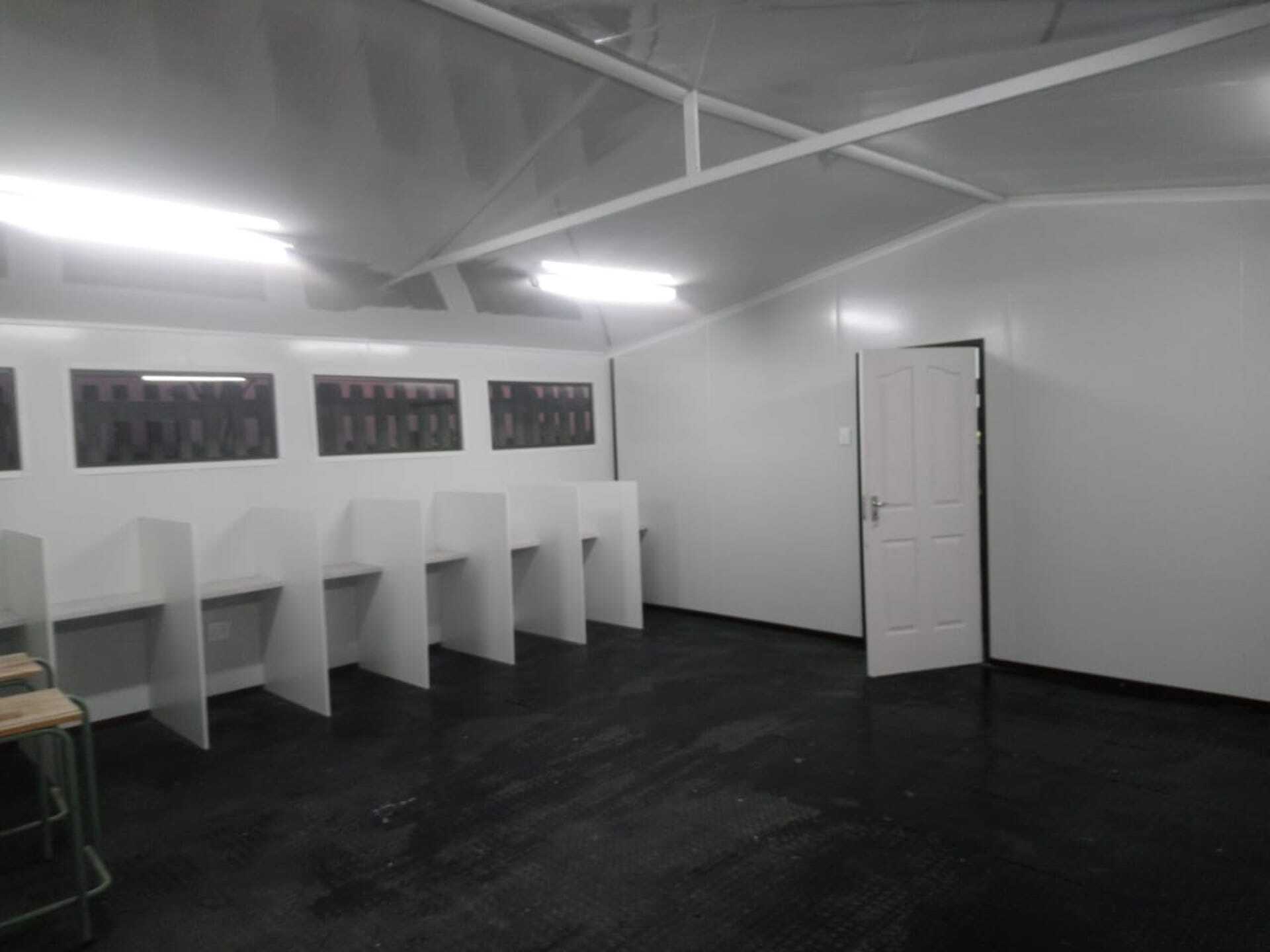 A room with a row of cubicles and a door