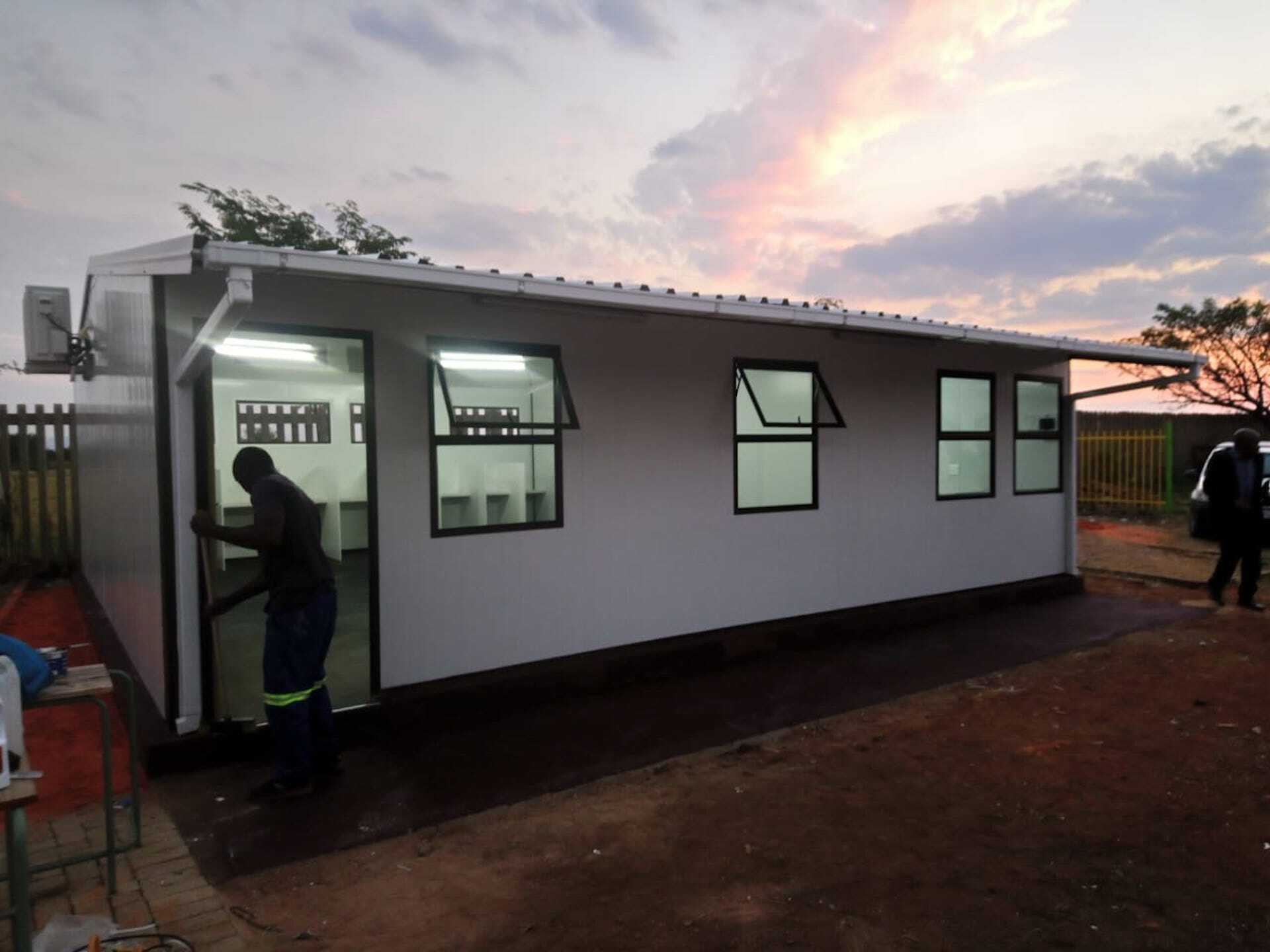 A man is standing in front of a white building