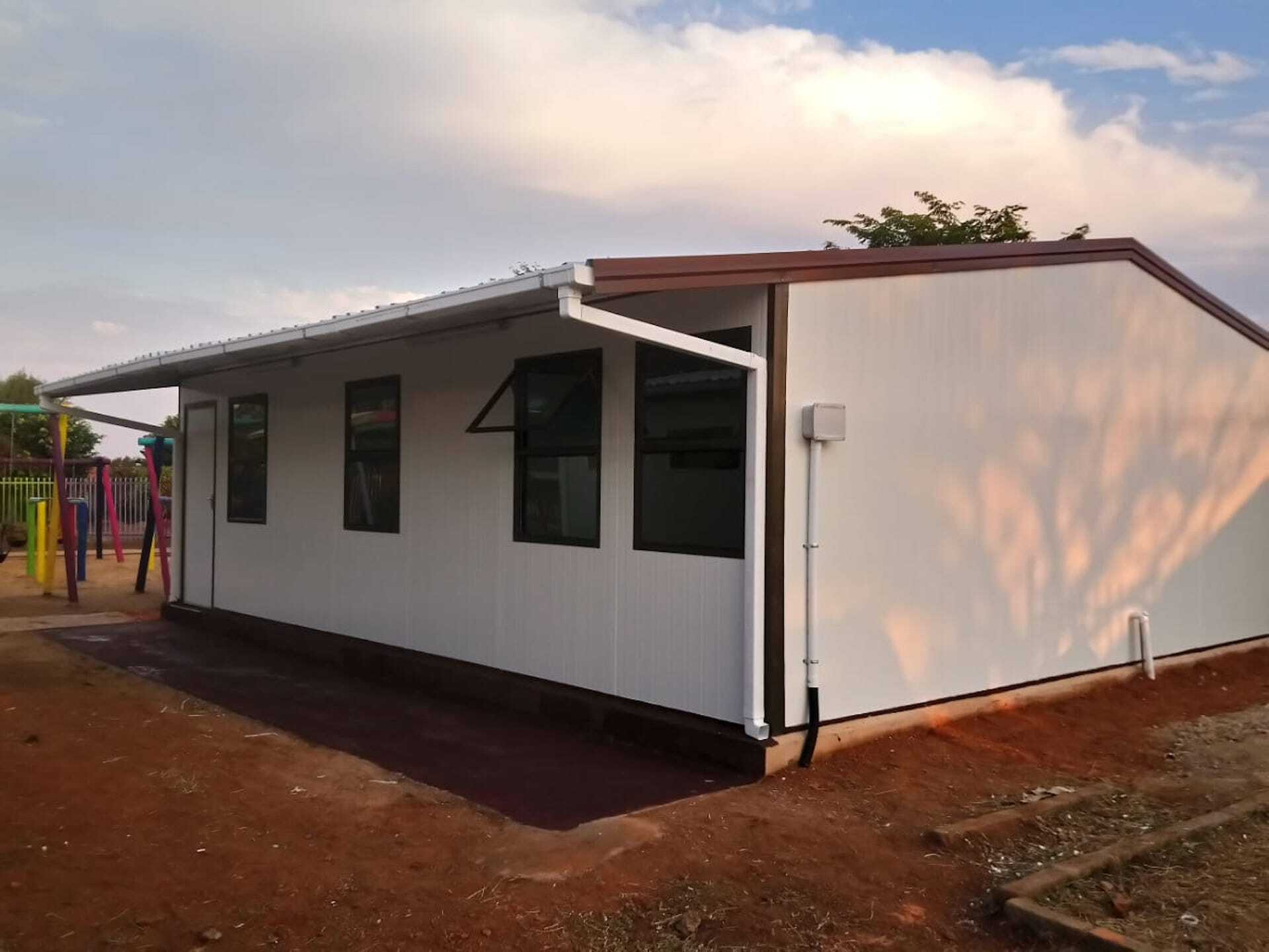 A white house with a playground in the background