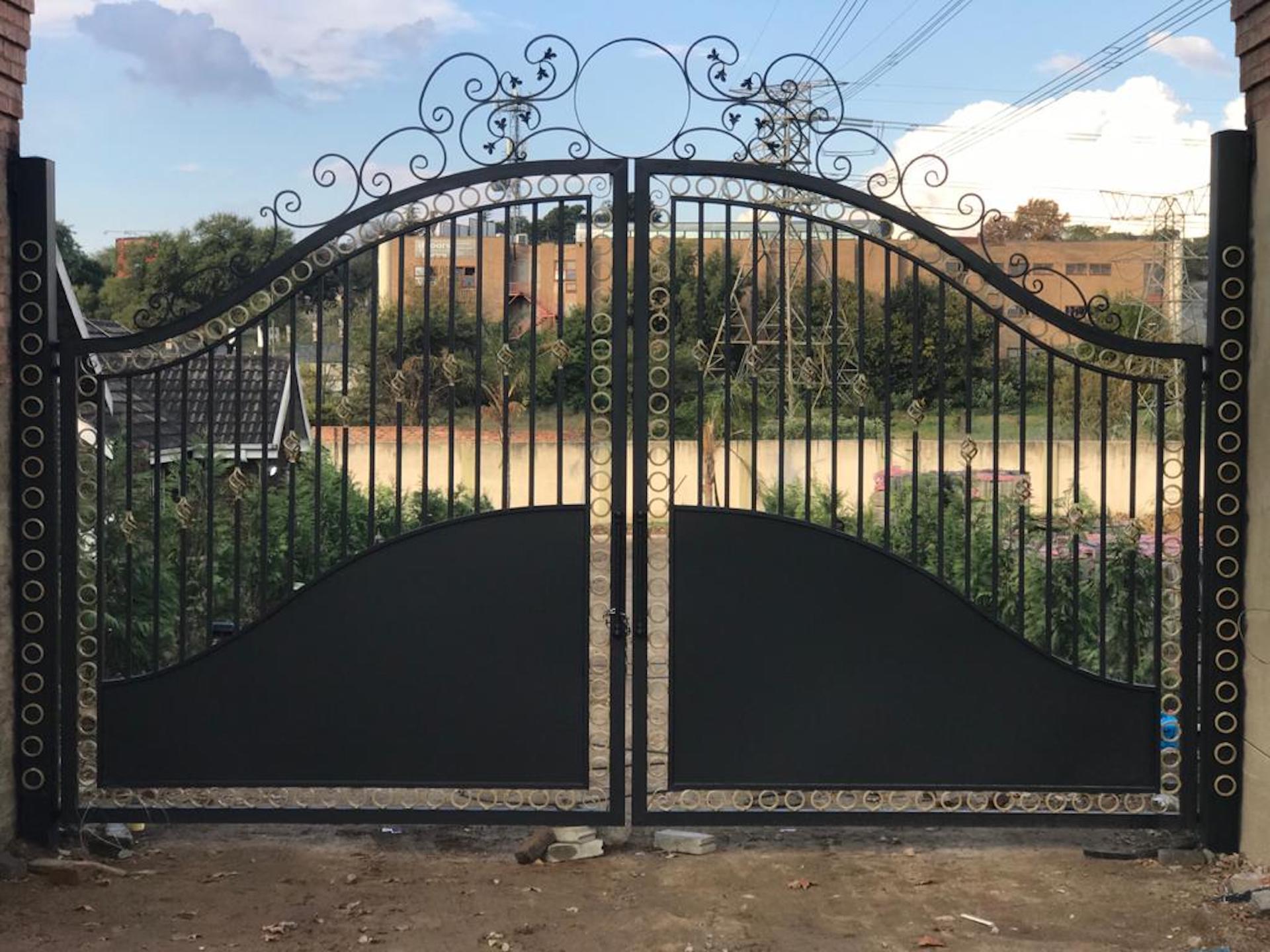 A wrought iron gate is sitting in front of a house.