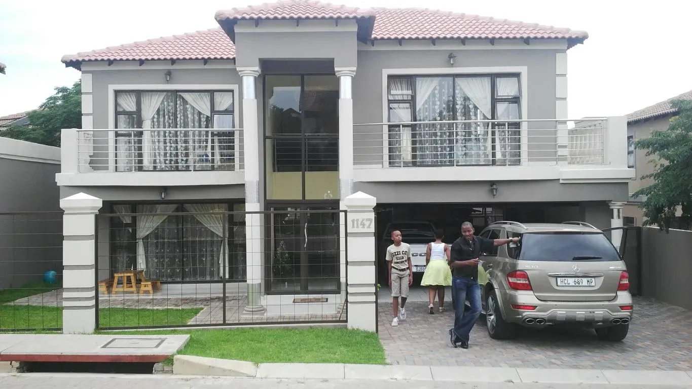 A mercedes benz is parked in front of a large house