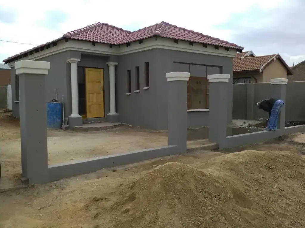 A house that is being built with a fence around it