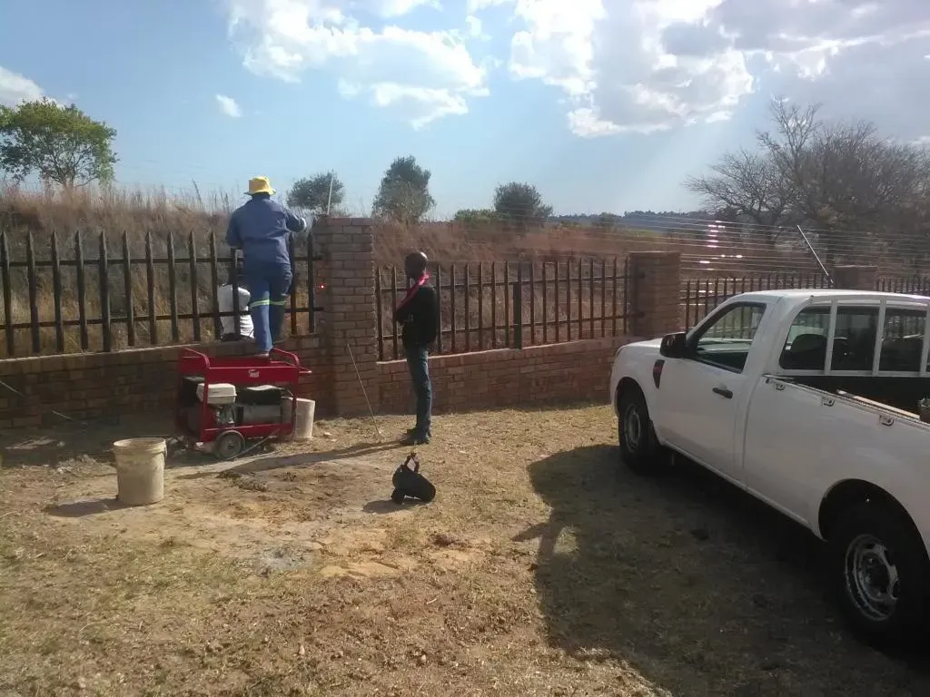 A white truck is parked in front of a brick wall