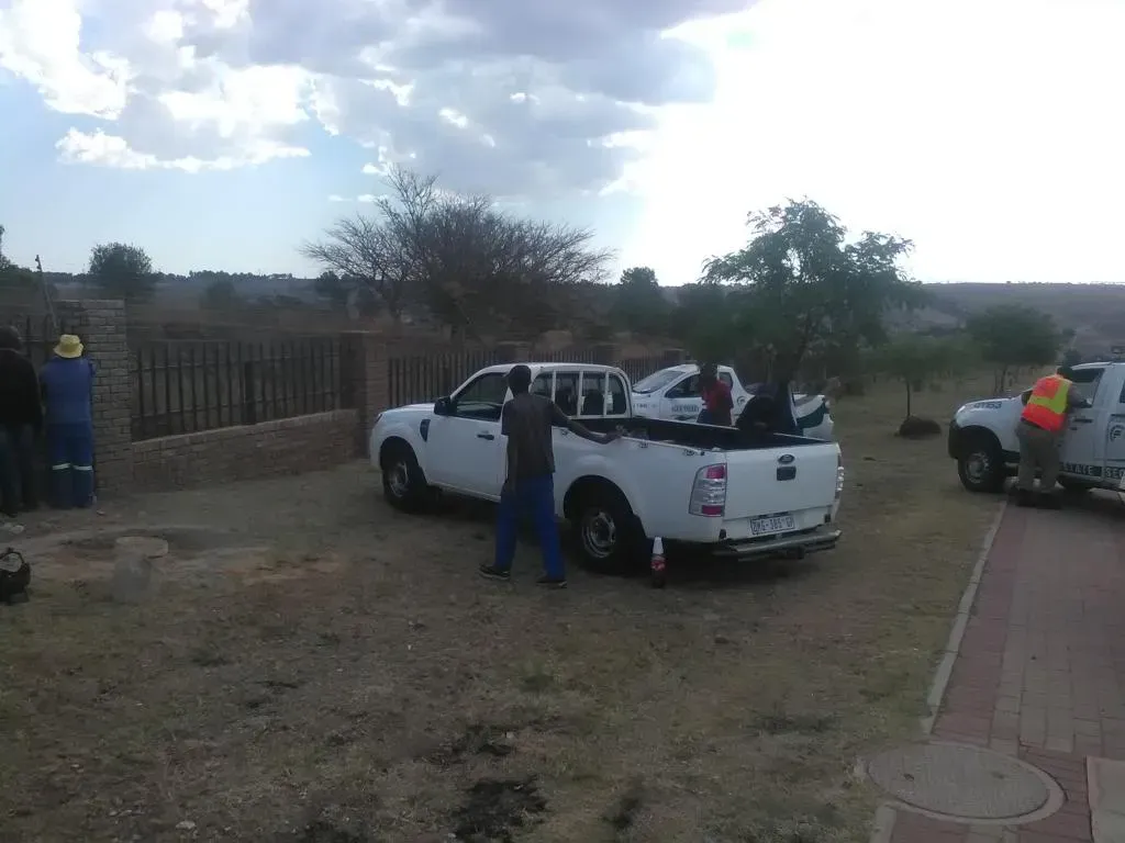 A group of people are standing around a white truck.