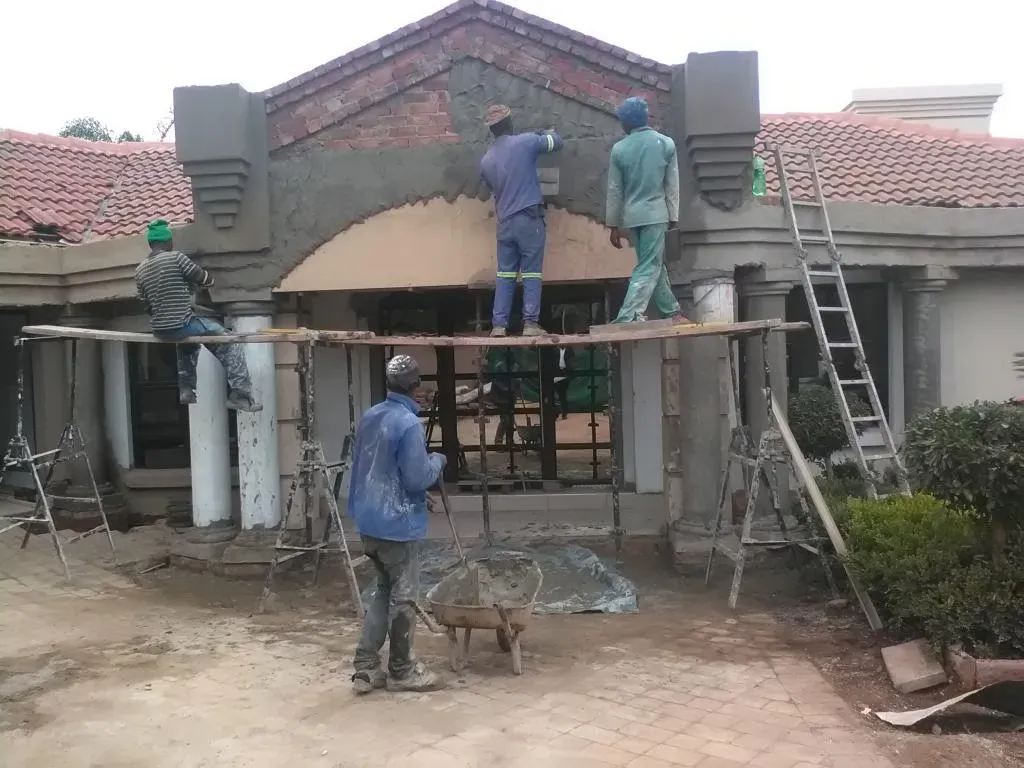 A group of construction workers are working on a building.