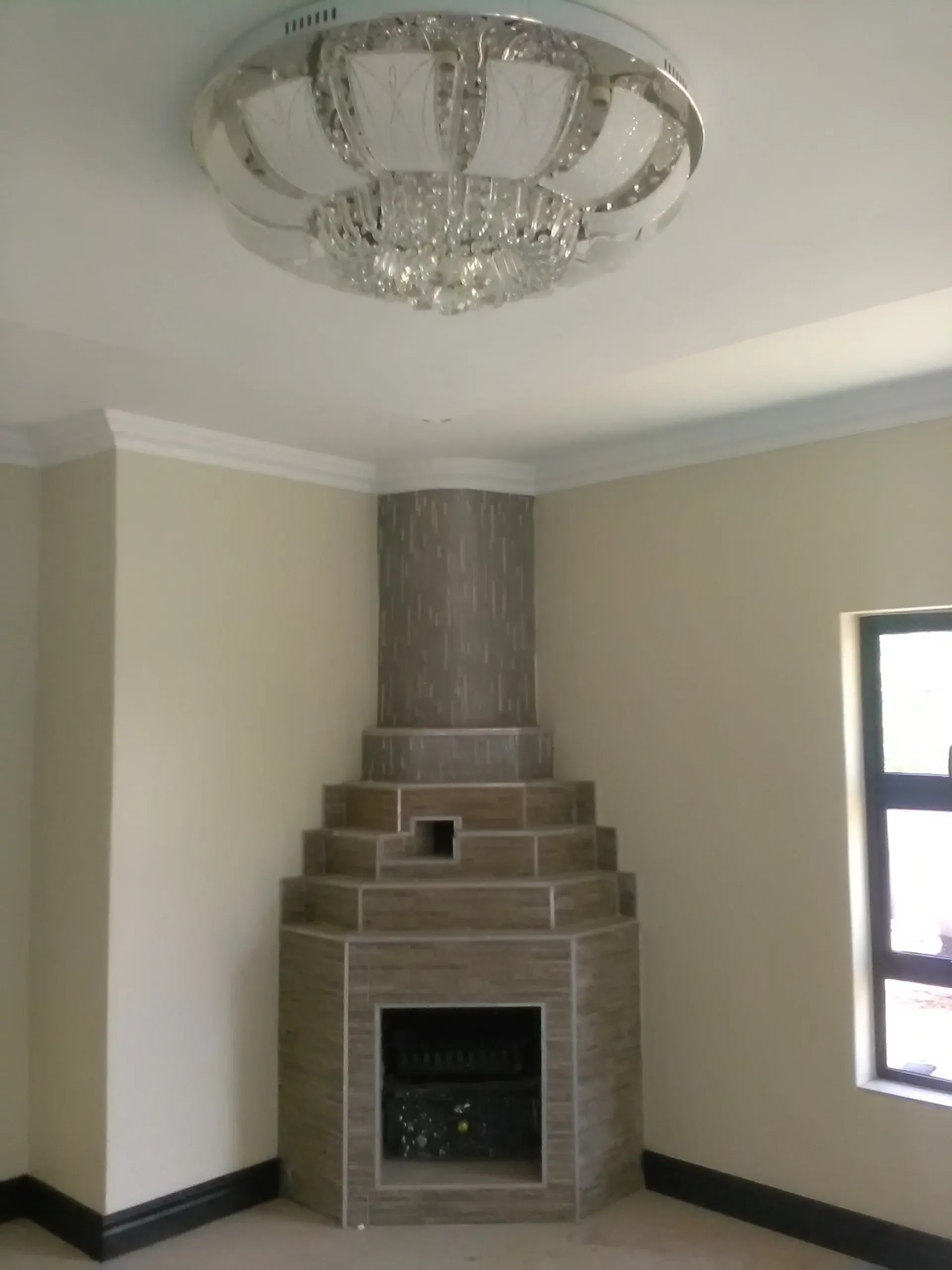 An empty room with a fireplace and a ceiling light