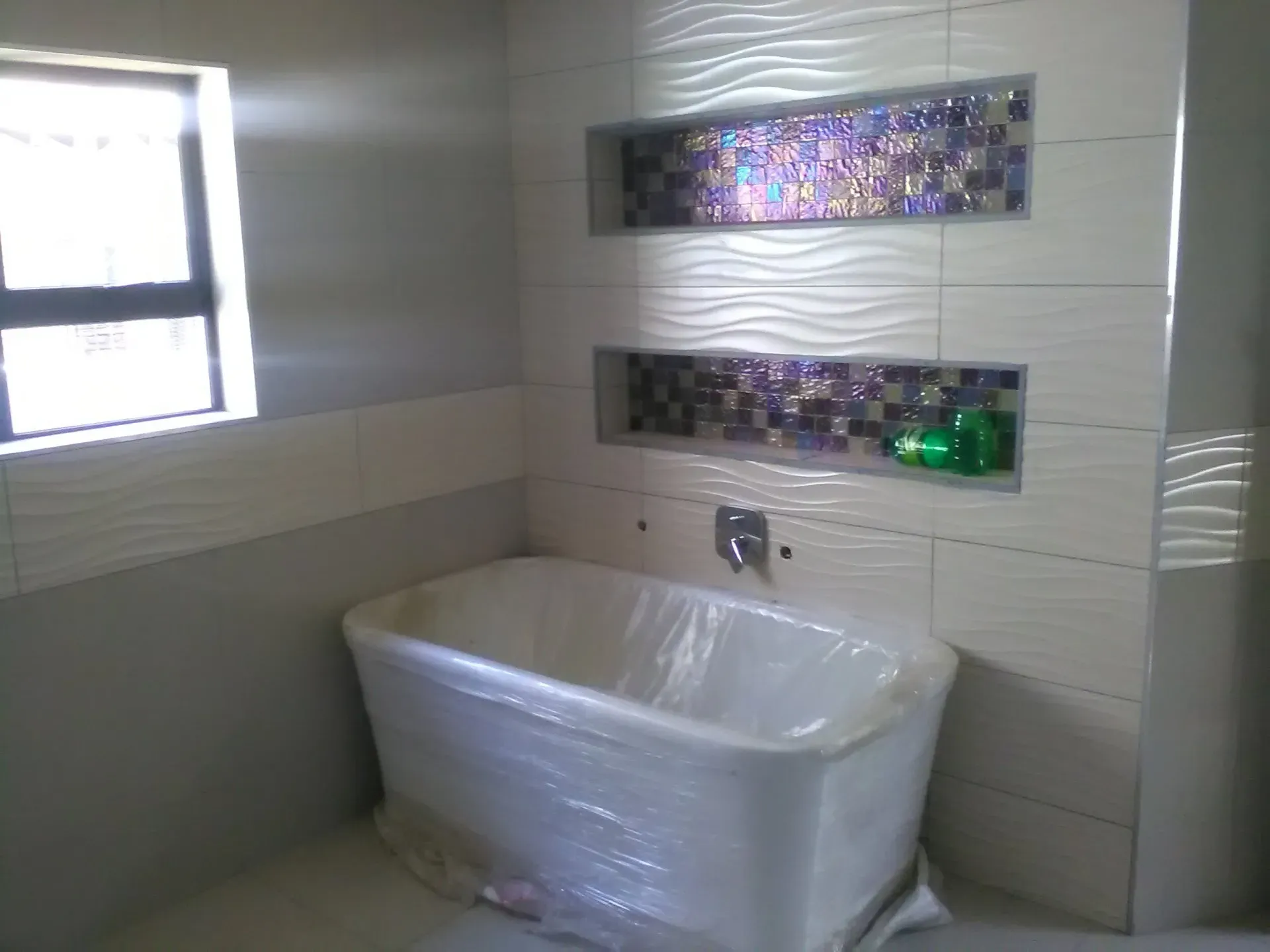 A bathroom with a bathtub and a window.