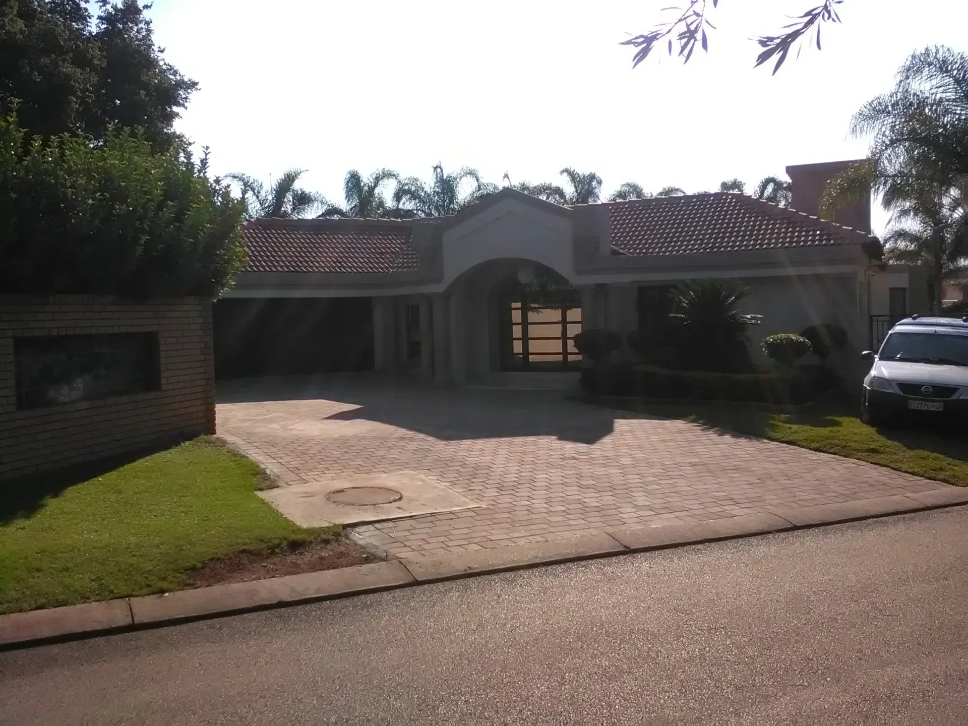 A white car is parked in front of a house