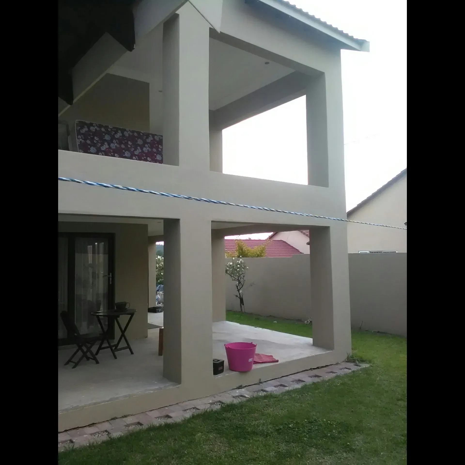 A large house with a pink bucket in front of it