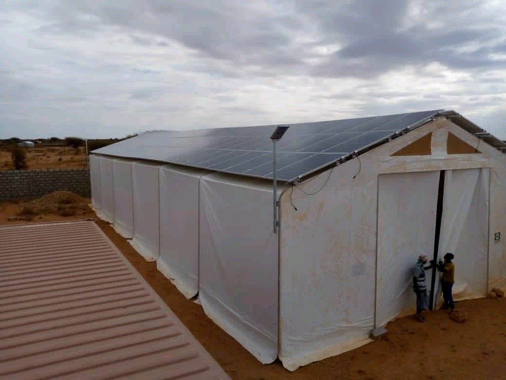 A large white tent with solar panels on the roof