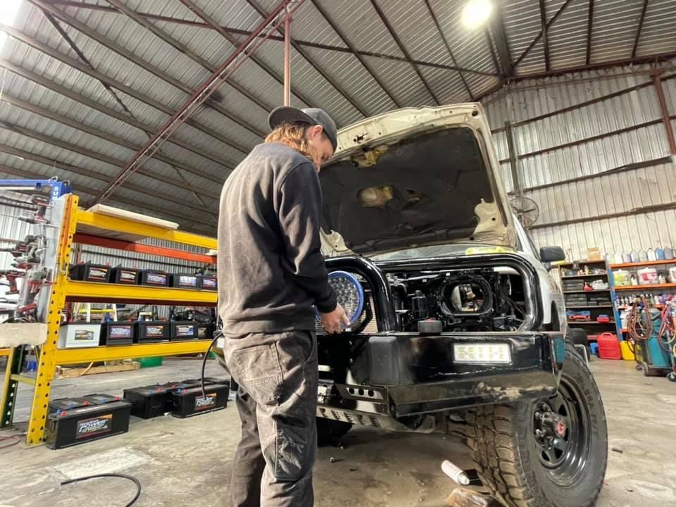 Mechanic Fitting Headlights to 4WD— AEQ - Auto Electrics QLD in Woombye, QLD