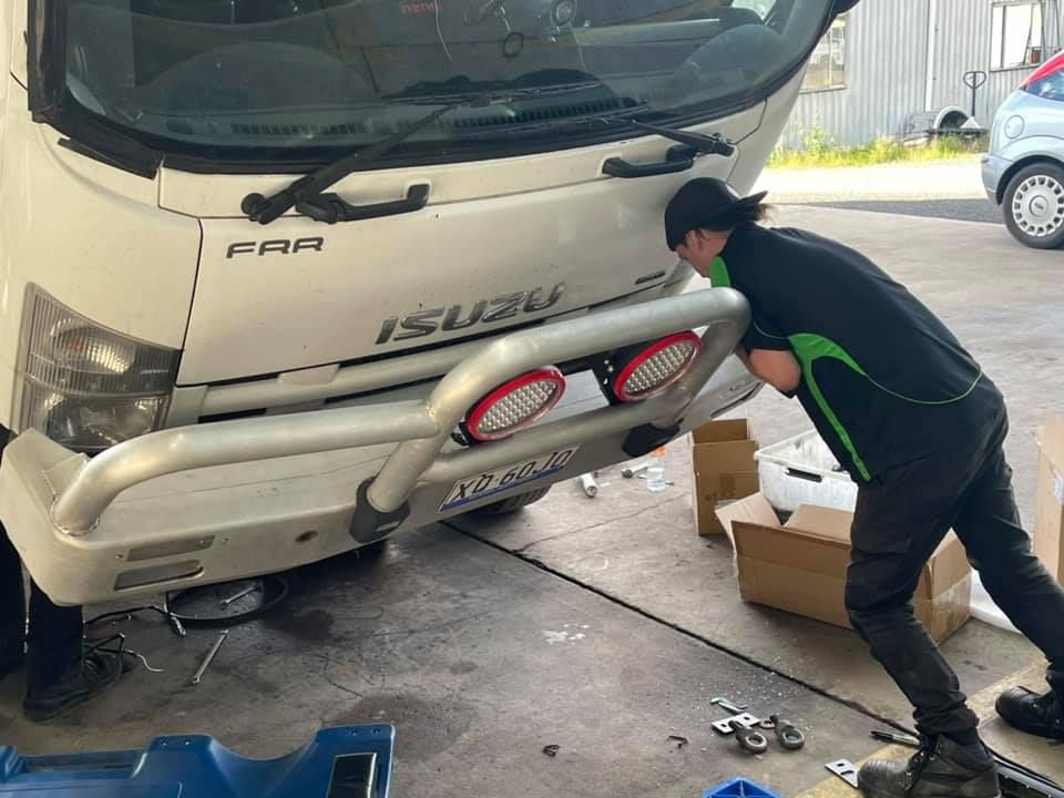 Mechanic With Truck Chassis Tilted Forward — AEQ - Auto Electrics QLD in Woombye, QLD