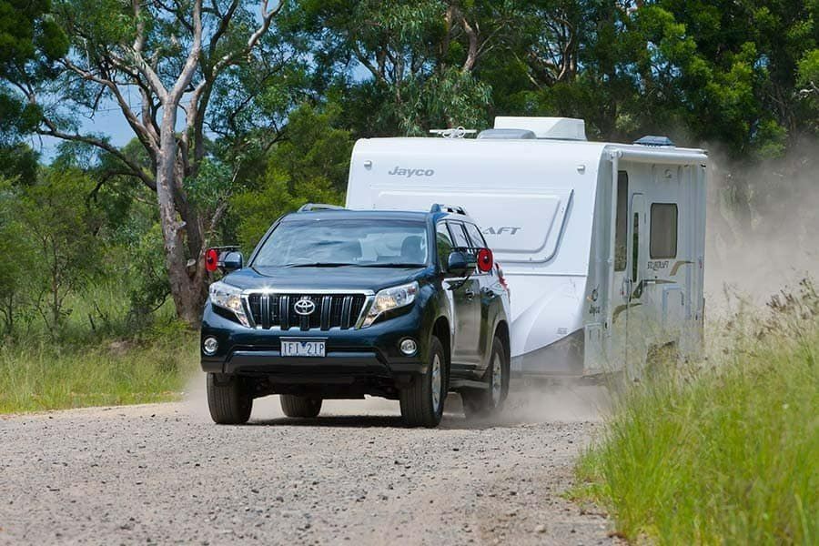 A Car is Towing a Trailer Down a Dirt Road — AEQ - Auto Electrics QLD in Woombye, QLD