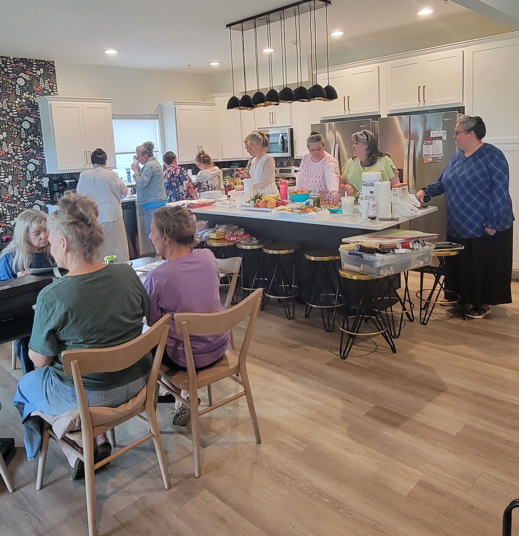 A group of people are sitting around a table in a kitchen.