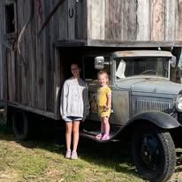 2 little girls in front of old vintage truck