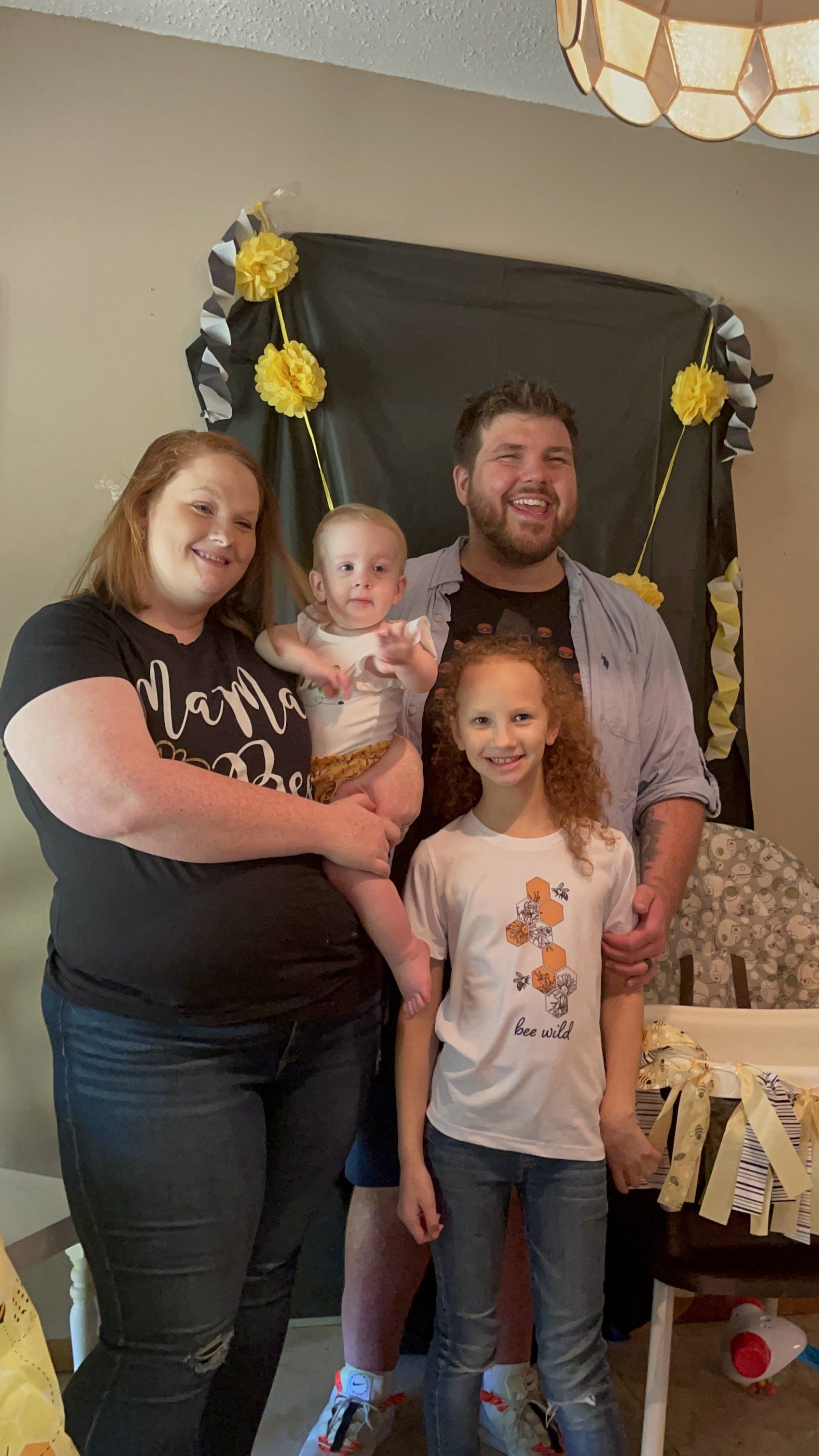 A family is posing for a picture in a living room.