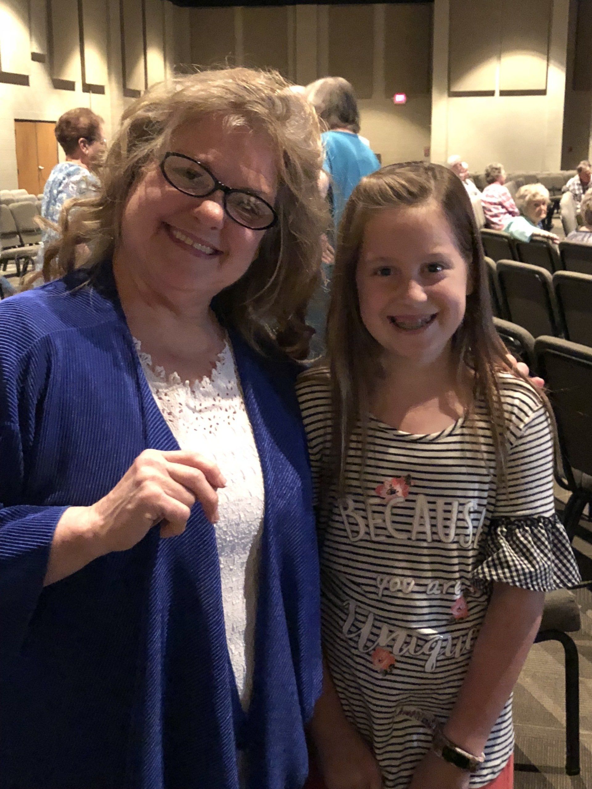 A woman and a little girl are posing for a picture and the girl is wearing a shirt that says because i hope