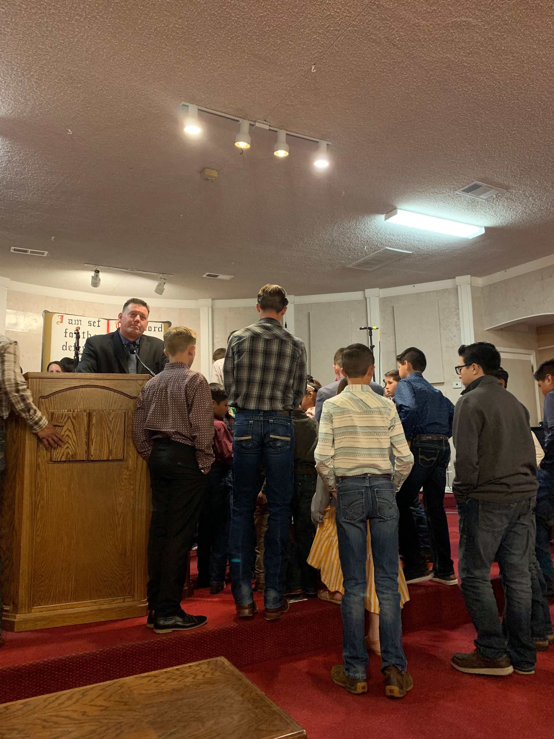 A group of people are standing around a podium in a church.