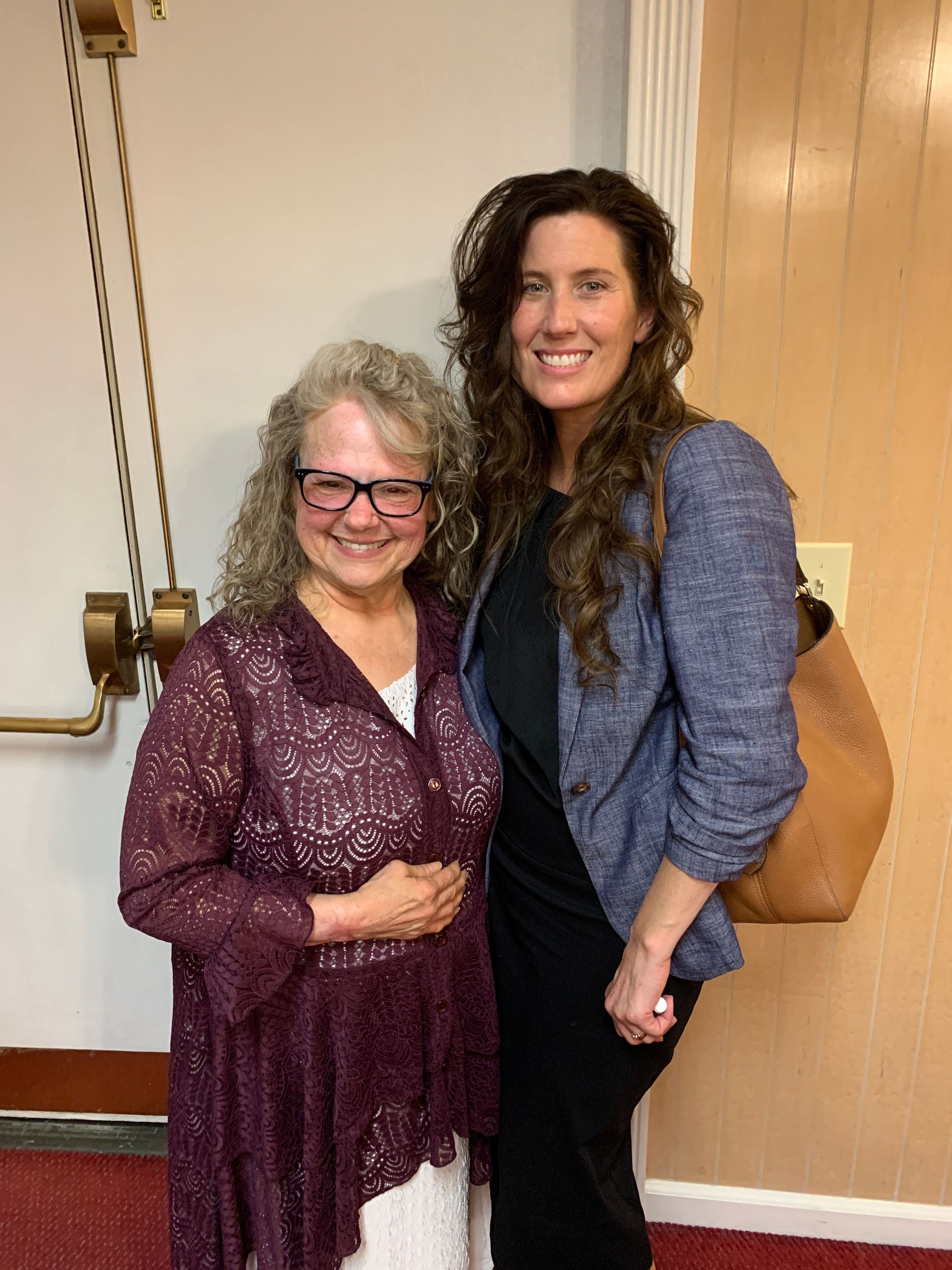 Two women are posing for a picture and one is wearing glasses