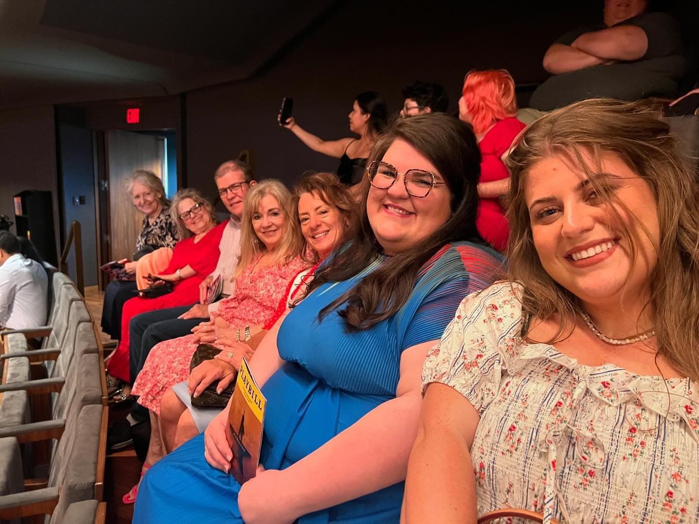 A group of people are sitting in a row in a theater.