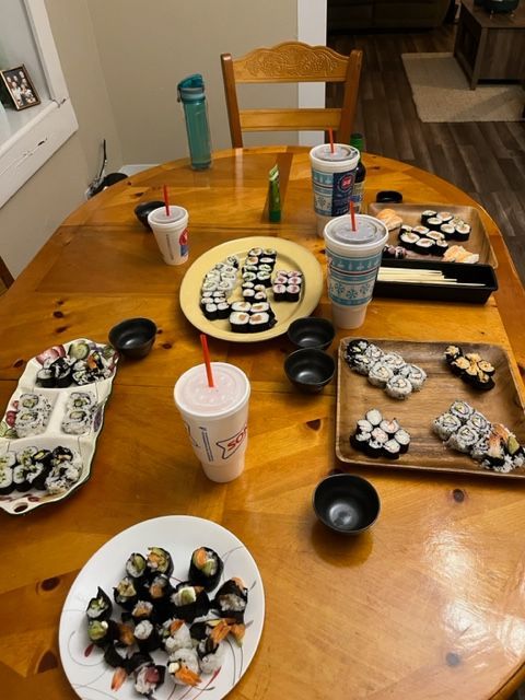 A table with plates of sushi and drinks on it