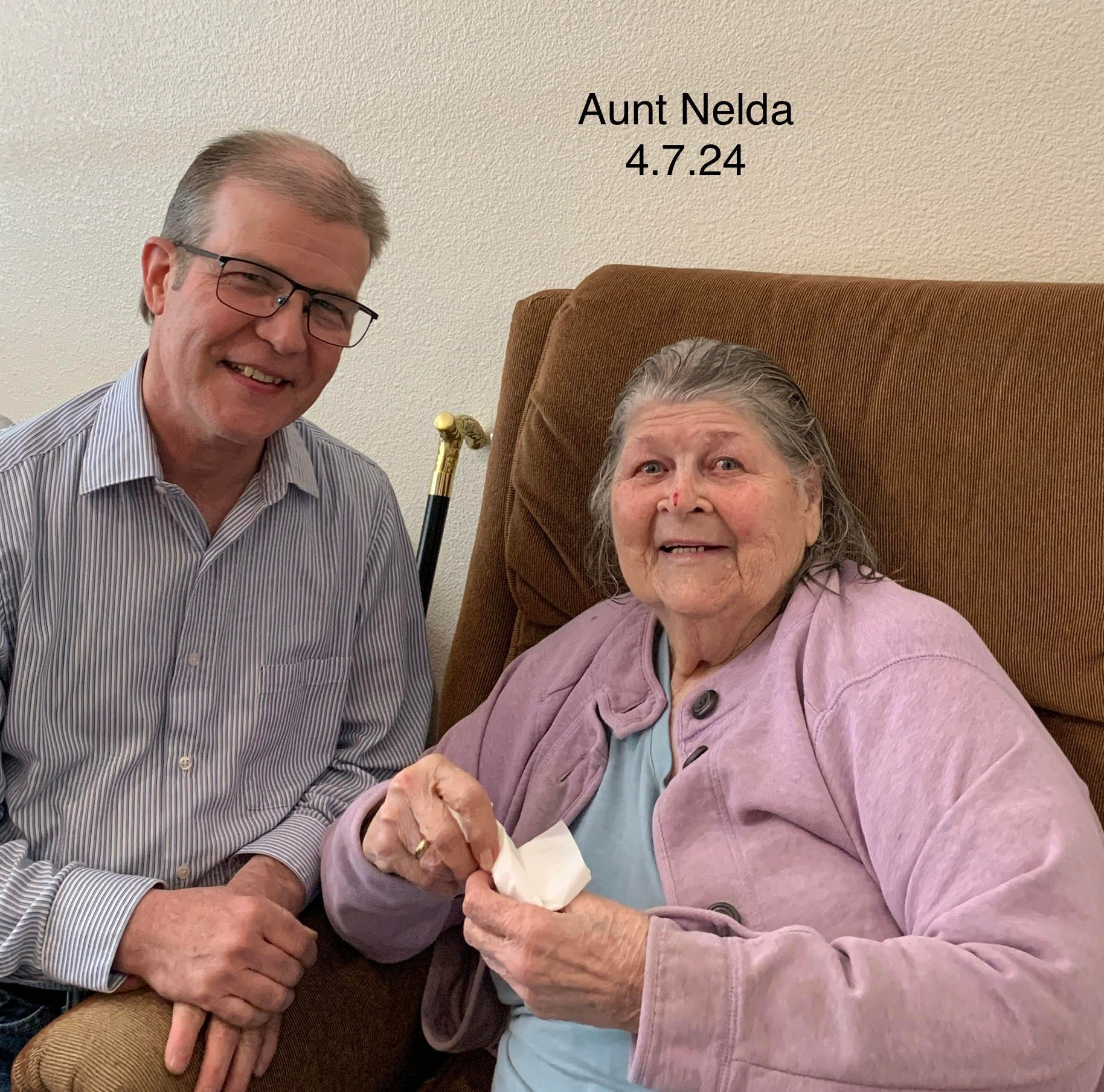 A man and a woman are posing for a picture with aunt nelda written on the wall behind them
