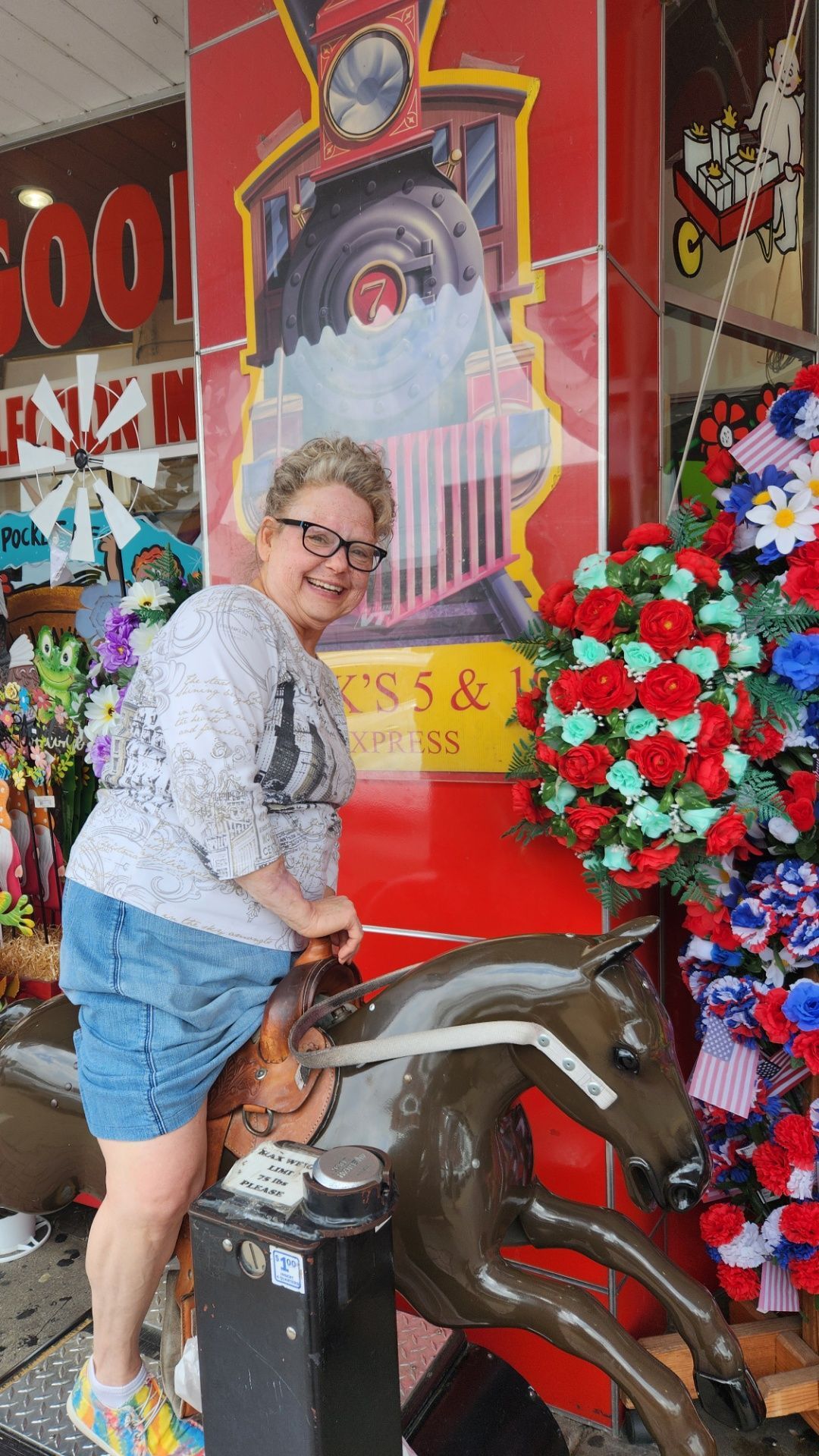 A woman is standing next to a statue of a horse.