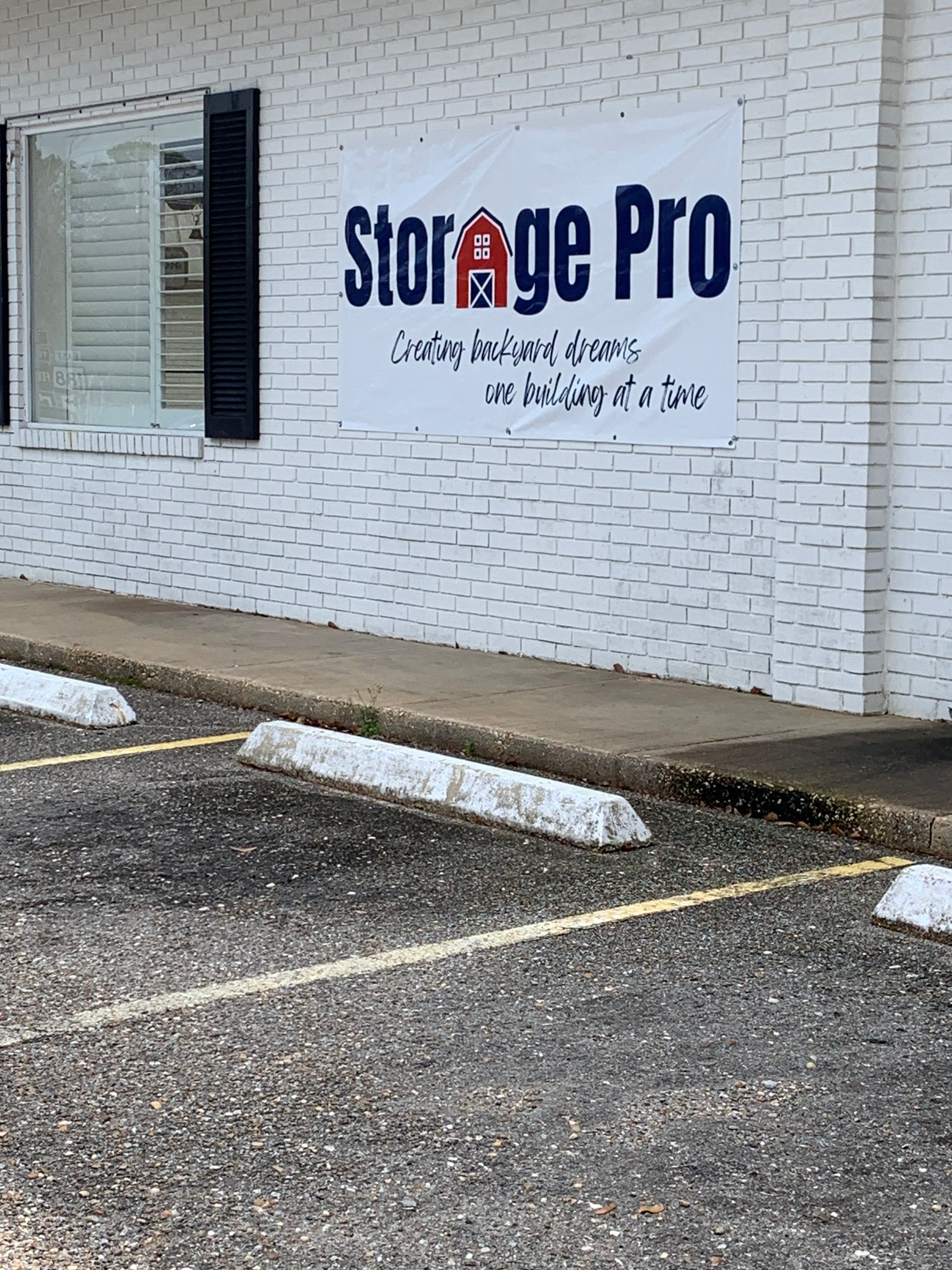 A parking lot in front of a storage pro building.