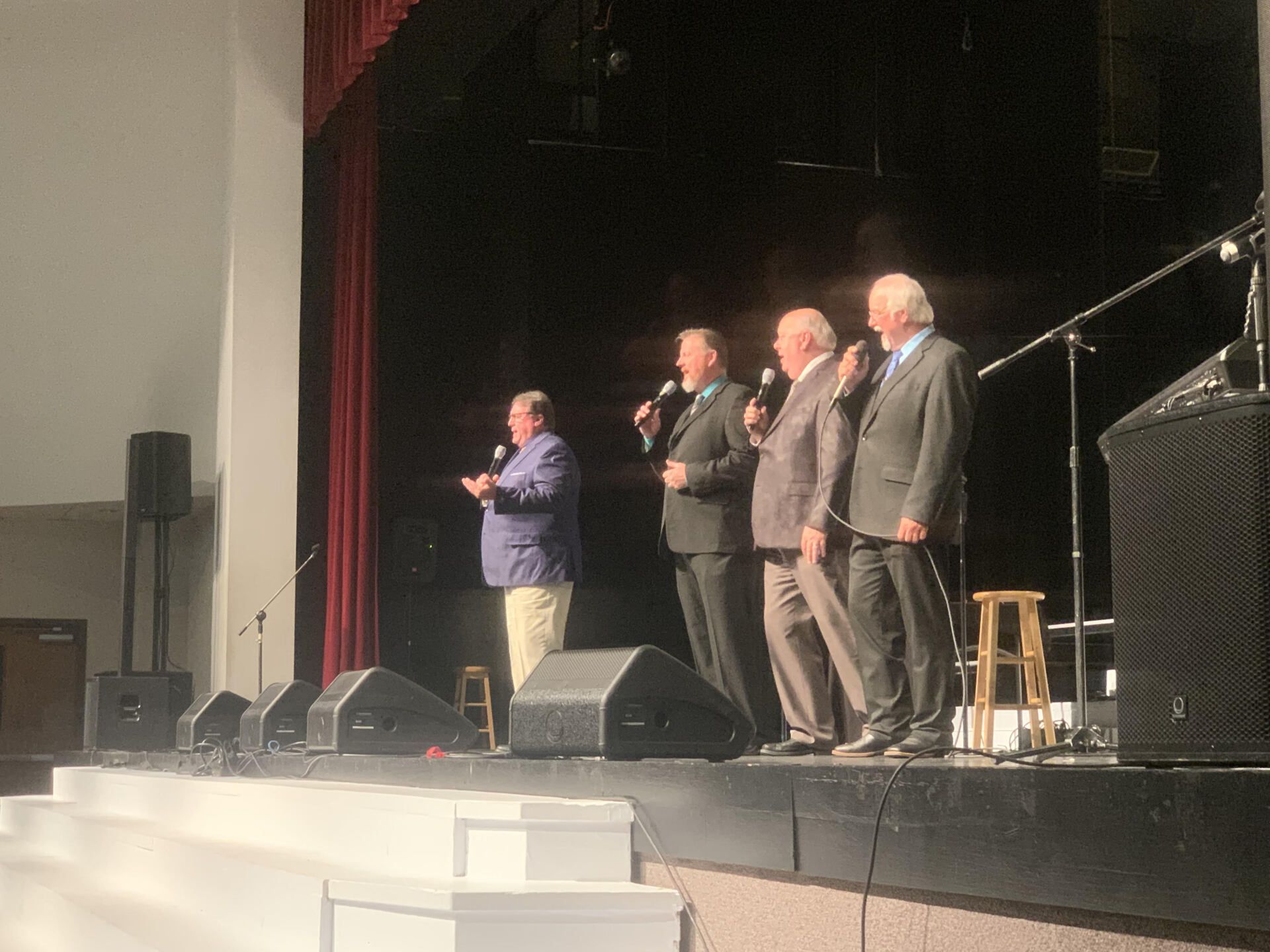A group of men standing on a stage holding microphones