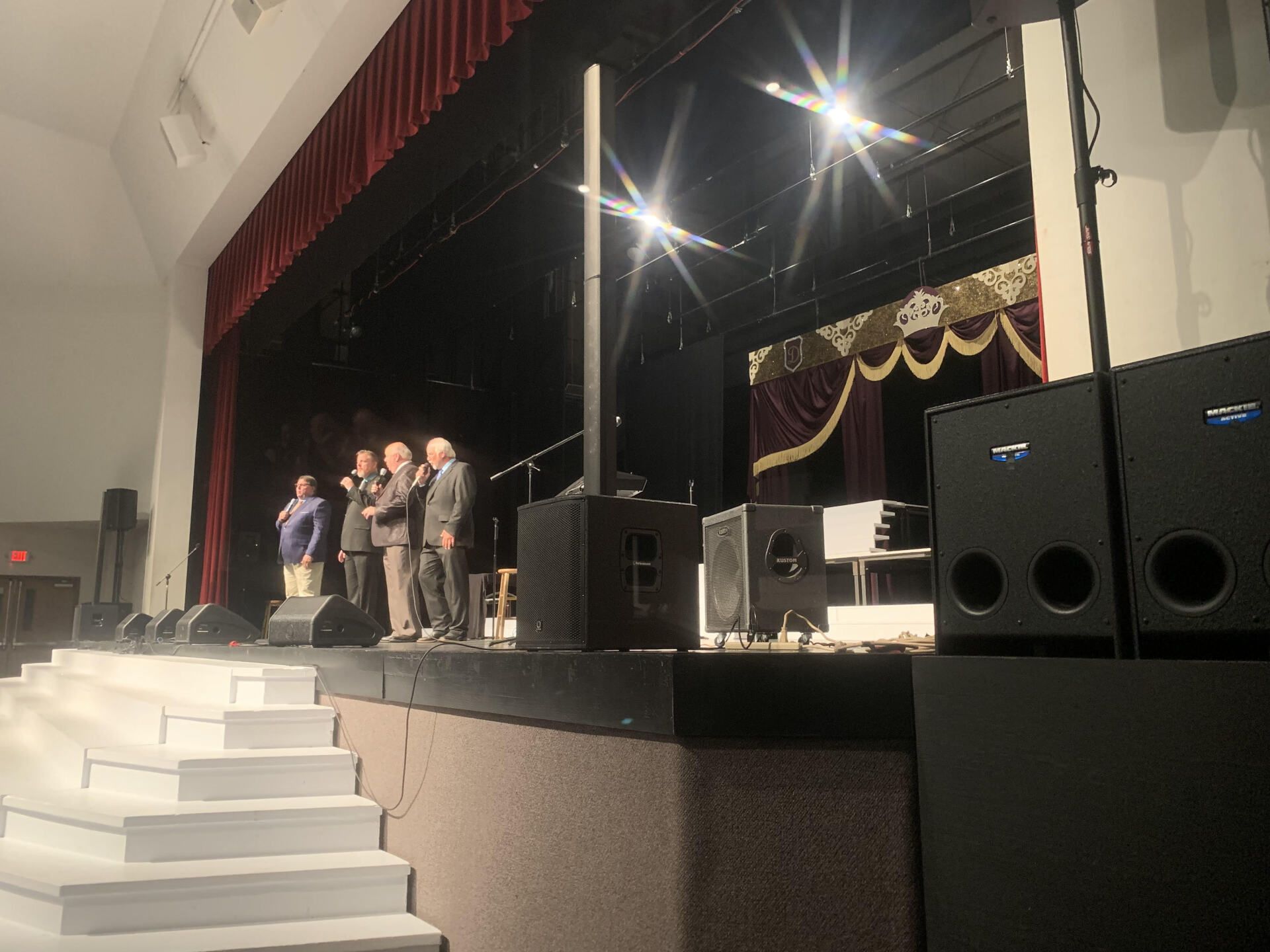 A group of people standing on a stage with speakers