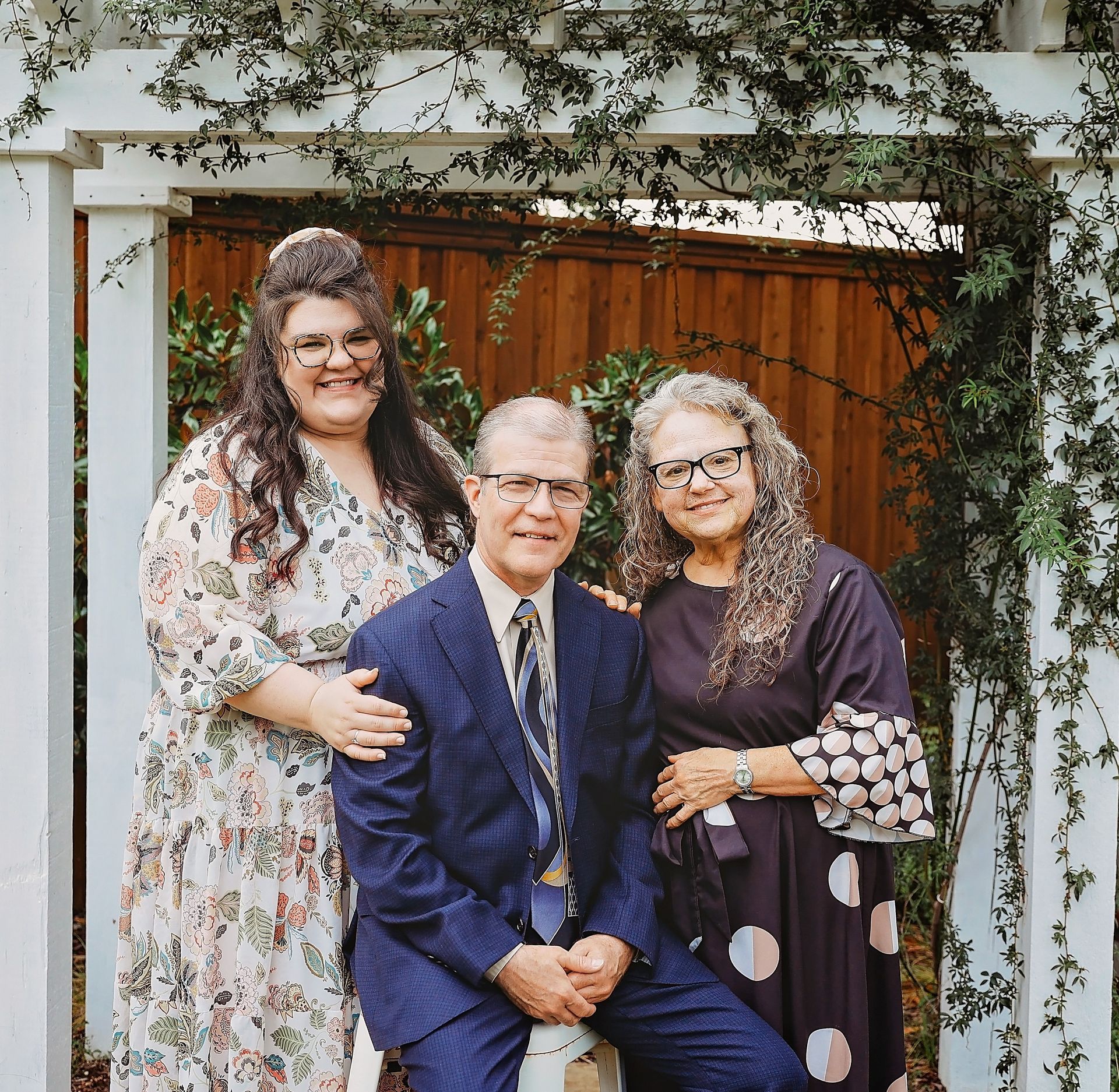 A man in a suit and tie is sitting between two women