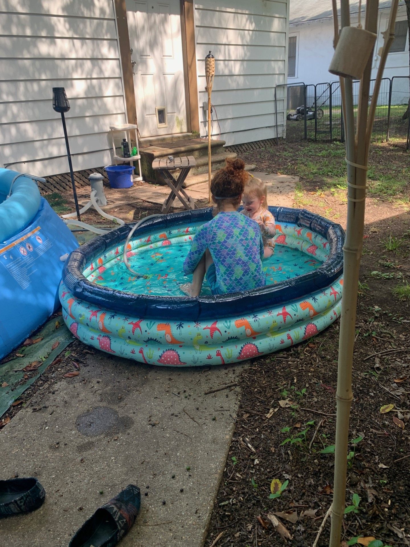 A woman and a child are sitting in an inflatable pool.