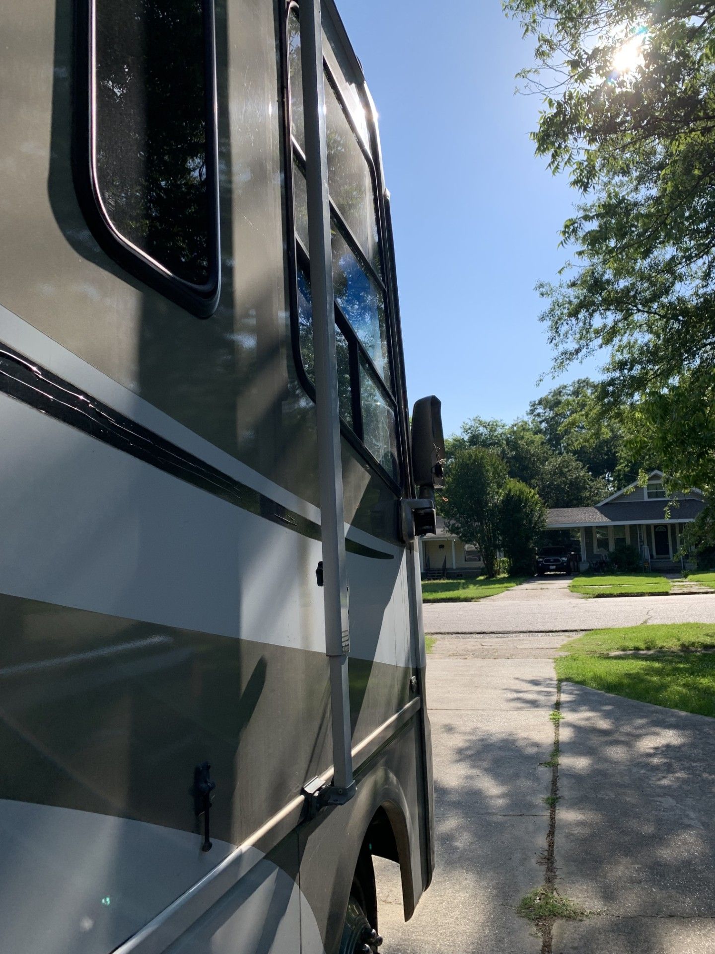 A rv is parked on the side of the road in a residential neighborhood.