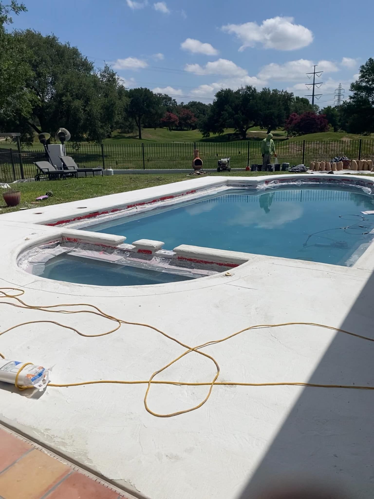 Pool with blue water and white concrete surround on a sunny day.