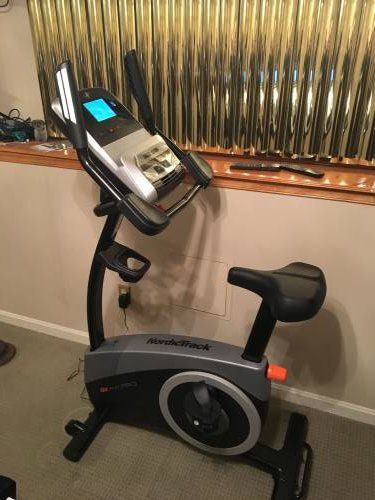 An exercise bike is sitting on the floor in a room next to a window.
