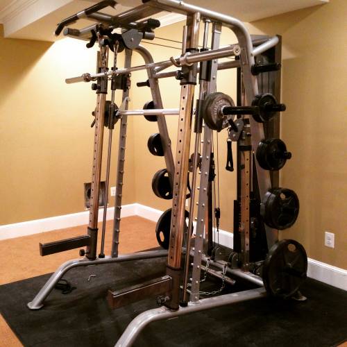 A Smith machine gym with a lot of weights on it