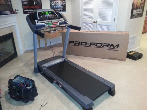 A treadmill is sitting next to a pro-form box